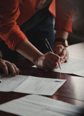 Deux personnes signent des documents contractuels à une table