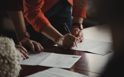 Deux personnes signent des documents contractuels à une table