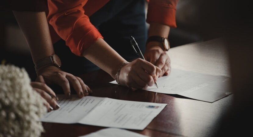 Deux personnes signent des documents contractuels à une table