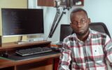 Développeur africain devant un écran de code et un microphone