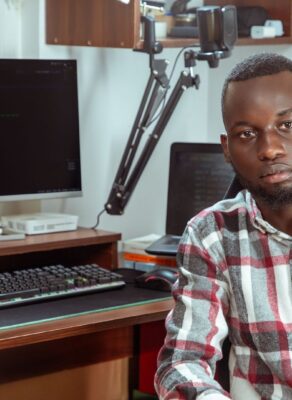 Développeur africain devant un écran de code et un microphone