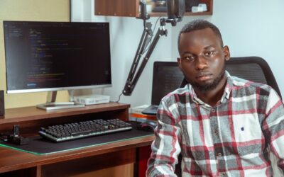 Développeur africain devant un écran de code et un microphone