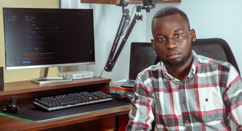 Développeur africain devant un écran de code et un microphone